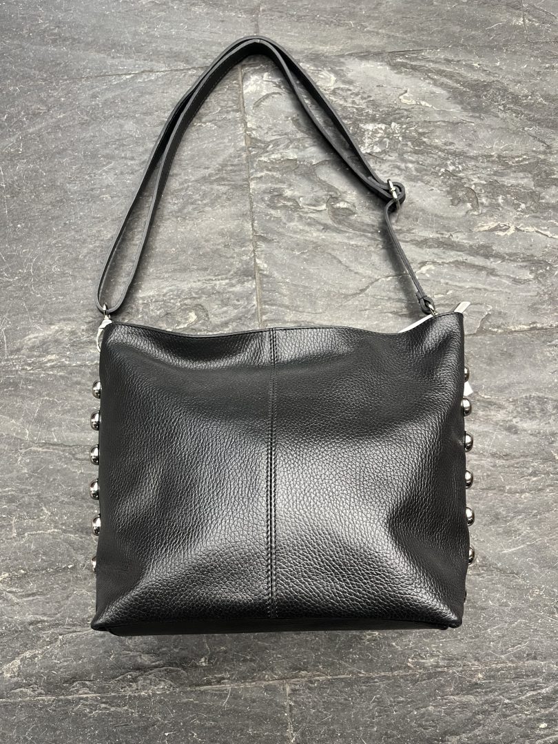 Bolso de piel negro con tachas laterales y asa larga de piel