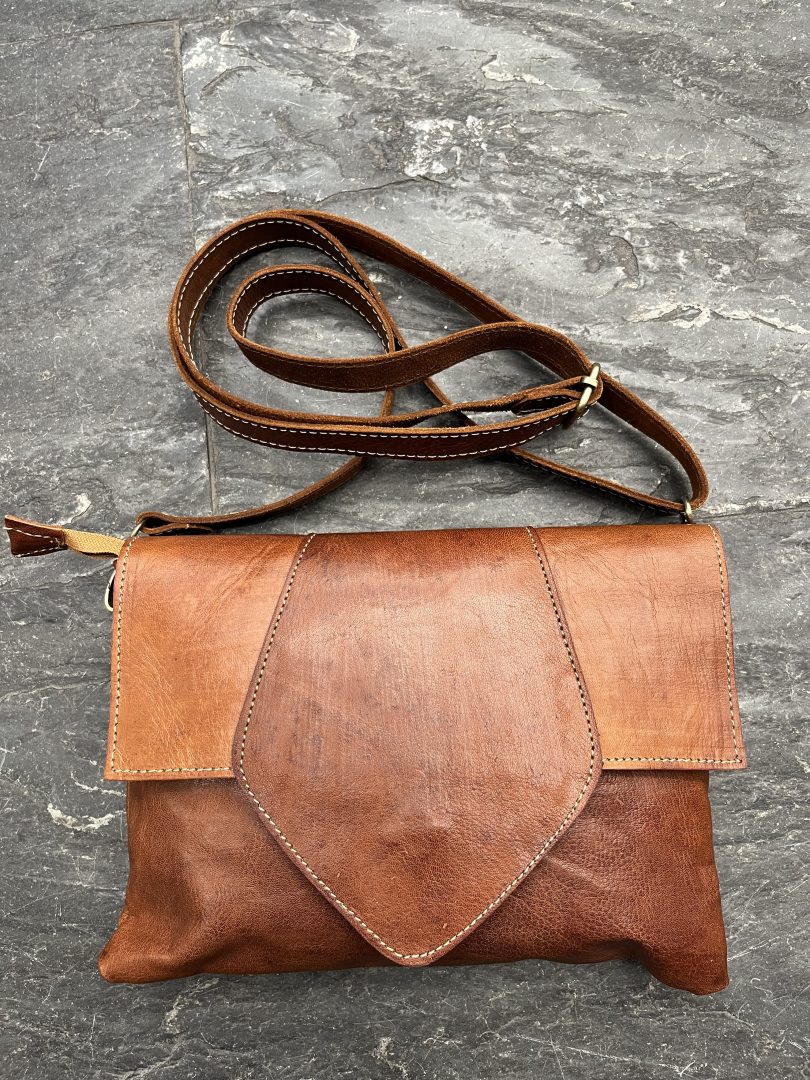 Bolso bandolera de cuero artesanal marrón con solapa y correa larga